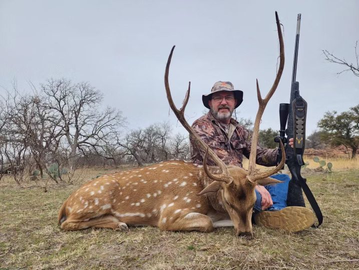 Hunter with an axis buck