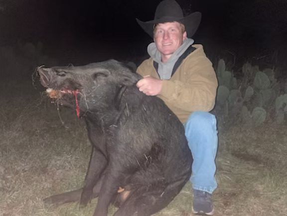 Hunter with a hog at night